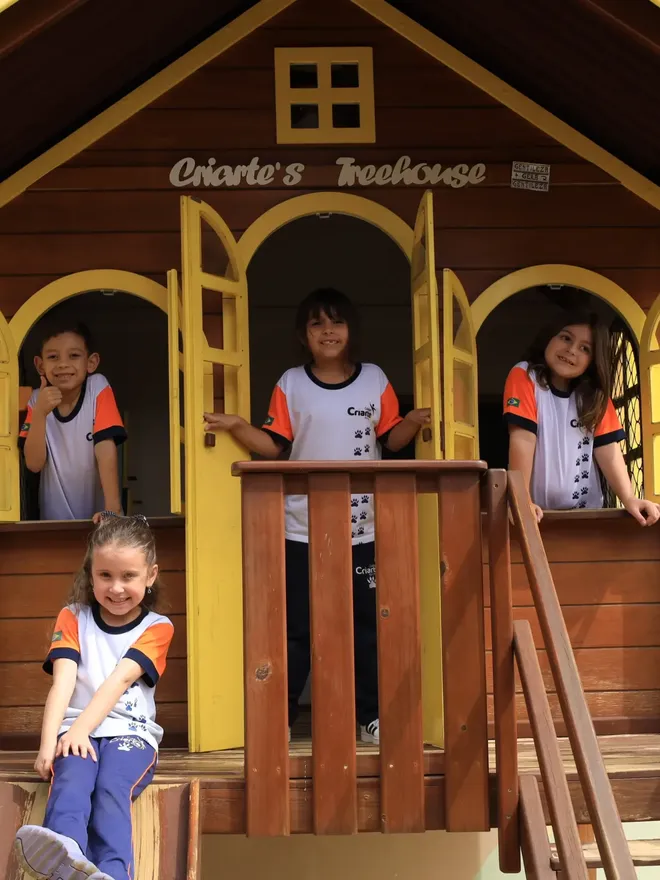 Crianças da Educação Infantil do Criarte brincando na casinha de madeira